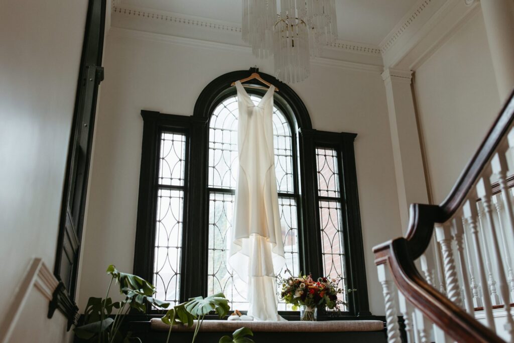 A wedding dress hangs at Blind Tiger, where the couple stayed for their Two Lights State Park Elopement in Portland, Maine. 