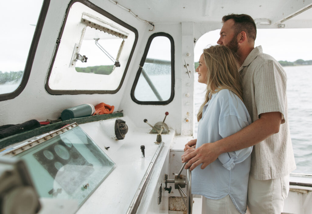 a couple rides in a lobster boat during their Portland, Maine engagement session